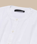 The Lara Top, made from Italian washed poplin with a button front and round neckline, is neatly folded and displayed on a beige background.