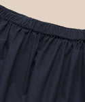Close-up of the elastic waistband on the Lauren Skirt in black, showcasing its lightweight comfort and cotton-like feel, set against a beige background.
