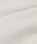 Close-up of the Linen Logan Pant’s white, textured fabric with gentle folds and subtle lines. The smooth, lightweight material is slightly wrinkled, evoking a relaxed feel—perfect for everyday wear.