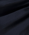 A close-up of the Logan Short’s dark, smooth fabric reveals soft folds and a gently textured surface with a satin-like, elegant finish.