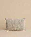 The Luna Lumbar Pillow, featuring a textured beige fabric cover and feather down insert, is placed against a matching beige background.