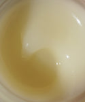 Close-up of Moisture Rich Balm, a creamy, semi-transparent formula swirled in its container. This pale yellow to off-white balm is infused with Sea Buckthorn Oil for deep moisture and a glossy finish.
