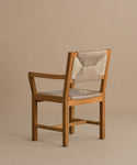 The Outdoor Montecito Dining Arm Chair Frame features armrests and a beige woven ECOLENE seat and backrest, set on a neutral floor with a plain beige background.