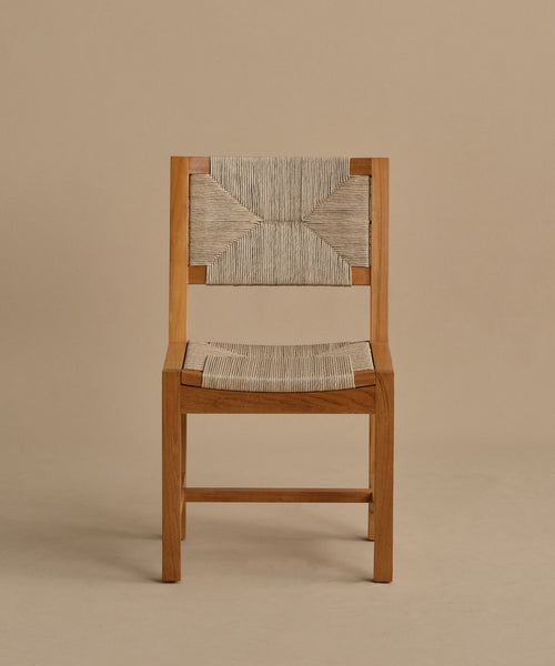 The Outdoor Montecito Dining Chair Frame features a simple, minimalist design with straight lines and an ECOLENE woven seat and backrest, crafted in teak wood and shown against a plain beige background.