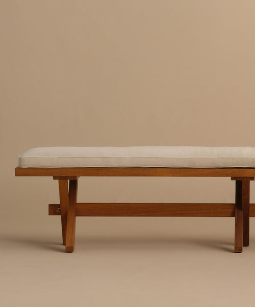 The Outdoor Garden Dining Bench has a simple modern design with a light beige Tempotest fabric cushion, set against matching neutral tan background and floor for a minimalist, cohesive style.