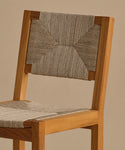 The Outdoor Montecito Dining Chair features a solid teak frame with a square seat and backrest, both woven in a geometric pattern with light-colored ECOLENE rope for a modern, minimalist outdoor look.