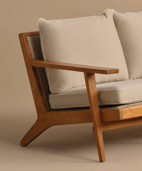 A close-up of the Outdoor Vista Sofa showcases its modern wooden frame and light beige Tempotest fabric cushions, featuring clean lines and a minimalist design against a neutral background.