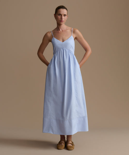 Woman wearing a light blue dress against a beige background