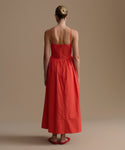 Woman wearing a red dress on a beige background