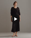 Thumbnail for video: Model walking in-studio wearing Pleated Skirt in Black.