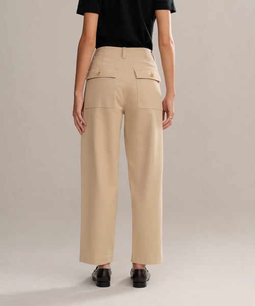 Someone stands facing away from the camera against a neutral background, wearing a black short-sleeve shirt, black shoes, and the Ranger Trouser—classic lightweight twill trousers with large back pockets.