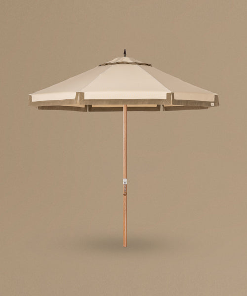 Beige patio umbrella with wooden handle on a beige background