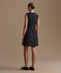 Woman wearing a black dress against a beige background