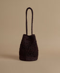 Brown woven handbag on a beige background