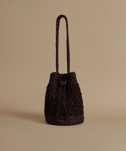 Brown woven handbag on a beige background