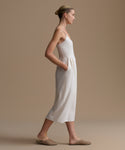 Woman wearing a white dress against a beige background