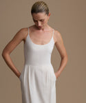 Woman wearing a white dress against a brown background
