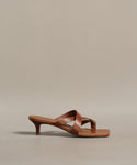 The Scarlett Heeled Sandal features brown leather, a low kitten heel, crisscross straps, and a square toe—displayed on a neutral background, it’s the ideal sunshine-approved summer footwear.