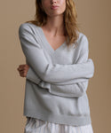 Woman wearing a light blue sweater against a beige background