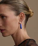 Close-up of a woman wearing a small angelika earrings with a blurred background