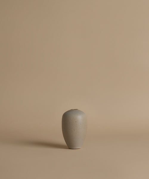 Gray ceramic vase on a beige background
