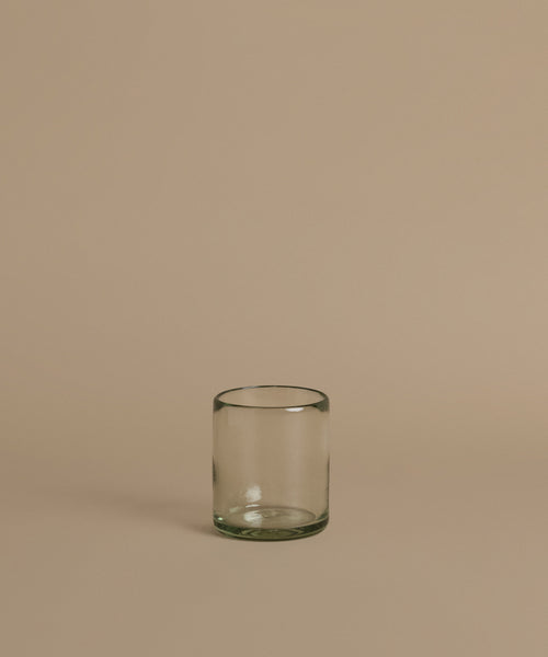 Recycled glass cup against a beige background.