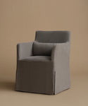 A modern upholstered armchair with a high back and a matching back cushion, covered in a textured gray fabric, set against a solid warm beige background.