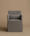 A modern gray upholstered armchair with a matching back cushion, set against a solid warm beige background.