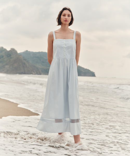 Woman wearing a light blue dress at the beach. 