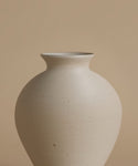 White ceramic vase on a beige background