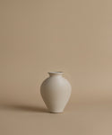 White ceramic vase on a beige background