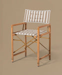Wooden director's chair with striped cushion on a beige background