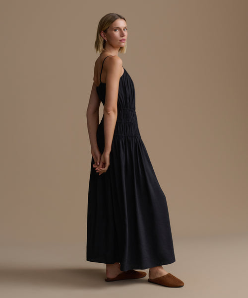 Woman wearing a black wynn dress against a beige background
