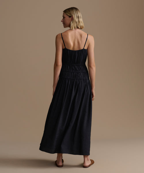 Woman wearing a black dress against a beige background