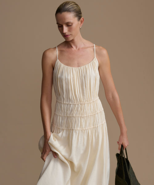 Woman wearing a cream wynn dress against a beige background