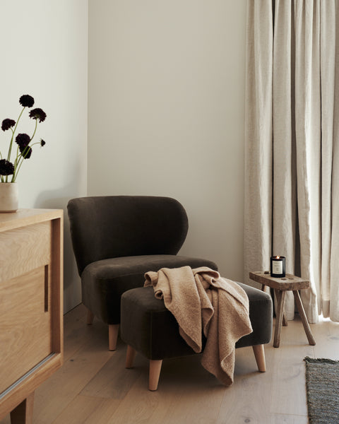 A chair and the Brentwood Ottoman, featuring mohair upholstery and a high-density foam cushion, bring comfort and style to the room.