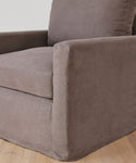 A close-up of a modern upholstered armchair in Fabric Swatch Charcoal Linen with plush seat, straight armrests, and set on a light wood floor—an elegant piece inspired by Jenni Kayne Furniture.