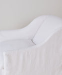A close-up of the Miramar Chair, featuring modern white linen upholstery, soft rounded edges, and a minimalist design, set against a light neutral background.
