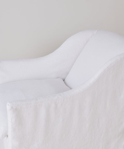 A close-up of the Miramar Chair, featuring modern white linen upholstery, soft rounded edges, and a minimalist design, set against a light neutral background.