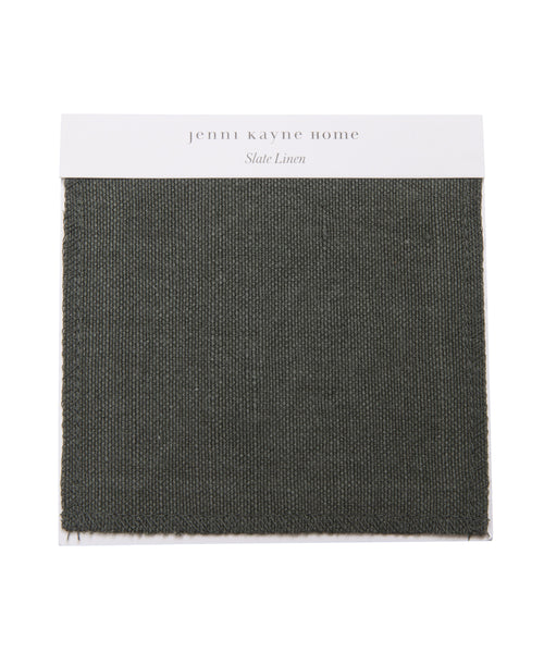 The Fabric Swatch Slate Linen by jenni kayne home features a textured, dark gray-green woven material on a white card, ideal for adding refined style to your Pacific Bed.