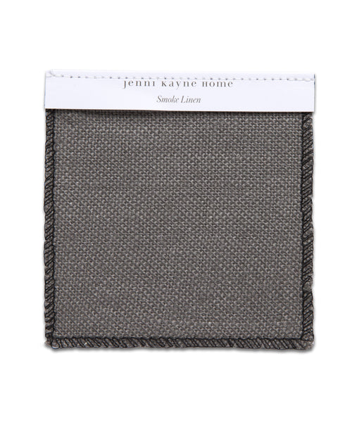 The Fabric Swatch Smoke Linen features a square, textured gray fabric with dark braided edges and a white label at the top—ideal for pairing with the Miramar Sofa.