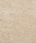 Close-up of the Sur Square Coffee Table’s light beige solid travertine surface, featuring natural holes, pores, and subtle variations in texture and color.