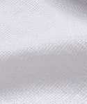 Close-up of the Miramar Sofa Slipcover, featuring white linen textured fabric with a woven diamond pattern and gentle folds. Its soft, slightly raised surface highlights an intricate weave—perfect for adding elegance to any sofa.